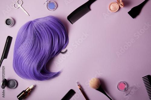 Obraz na plátně top view of violet wig, makeup tools and cosmetics on purple