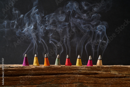 Incense sticks on old wood with smoke and black background photo