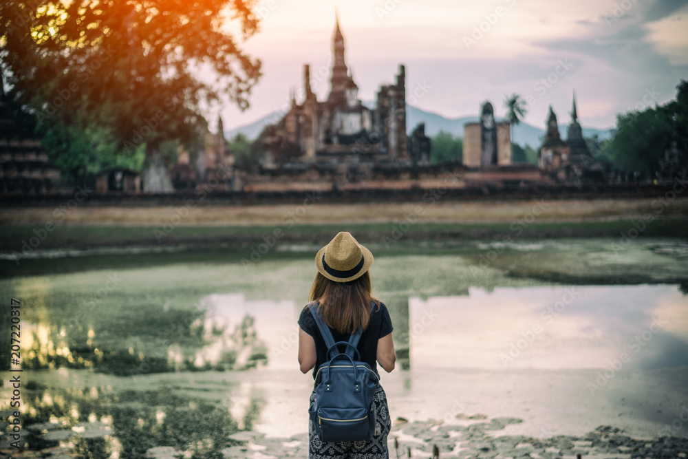 Young woman hipster backpacker traveling into Wat Mahathat temple