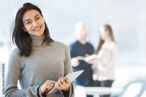 Portrait of beautiful businesswoman with tablet smiling at look at the camera photo