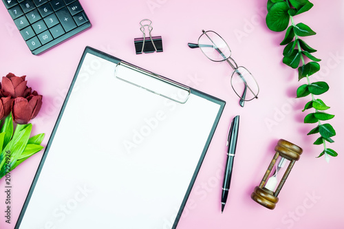 Women's stylish table. Workspace with blank white paper free space and pen in desk with flowers on pink pastel background for magazines, websites, media, Instagram. Flat lay, top view.