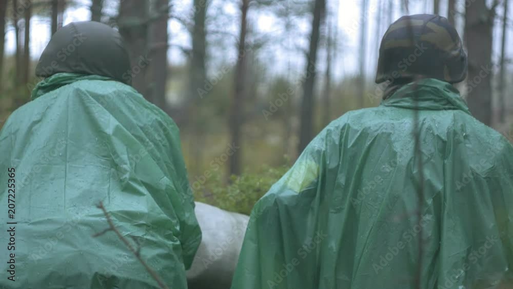 Soldiers in camouflage with combat weapons are being fired in the shelter of the forest, the military concept Soldiers in camouflage with combat weapons are being fired in the shelter of the forest, the military concept