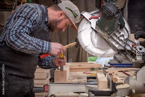 Bilde på lerret Carpenter work with circular saw for cutting boards, the man sawed bars, constru