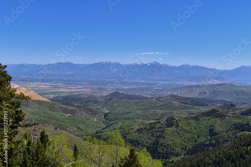 Fototapeta Naklejka Na Ścianę i Meble -  Panoramic view of Wasatch Front Rocky Mountains from the Oquirrh Mountains, by Kennecott Rio Tinto Copper mine, Utah Lake and Great Salt Lake Valley in early spring with melting snow and Cloudscape. U