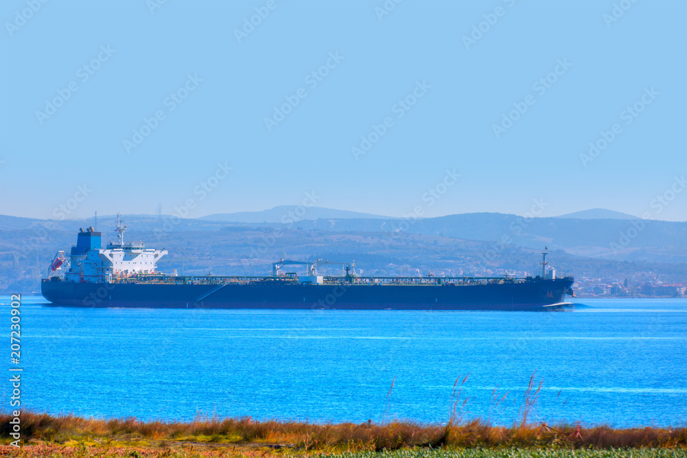 Large cargo ship passing through in Canakkale strait against Canakkale city