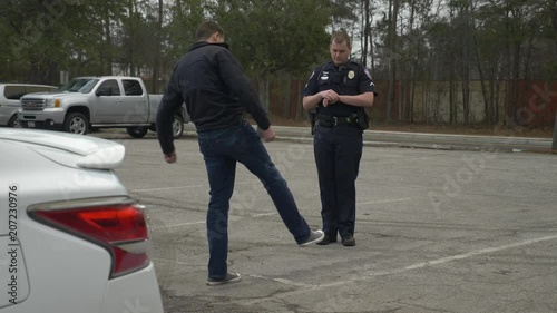 A drunk person tries to pass a DUI test during a traffic stop with a police officer.