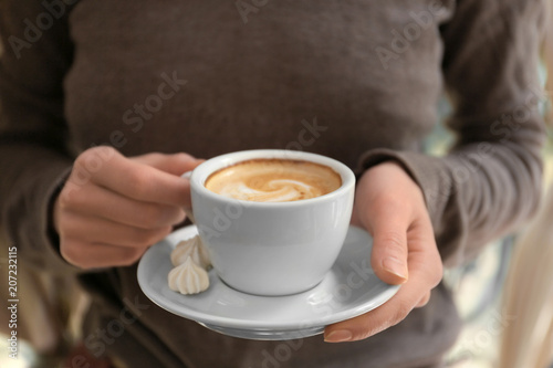 Young woman with cup of delicious coffee, closeup