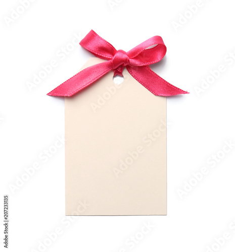 Blank gift tag with satin ribbon on white background, top view