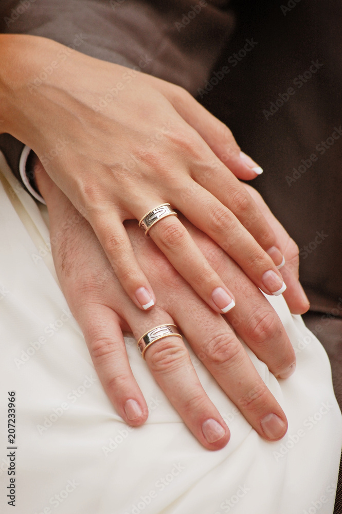 The bride and groom hold hands together with rings The bride and groom hold hands together with rings