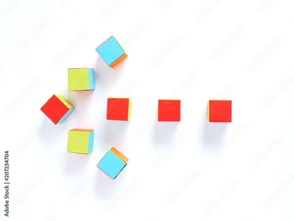 Arrow mark made from multi-colored paper cubes, origami, isolated on white background, top view. Concept school, children, toys, game . Arrow mark made from multi-colored paper cubes, origami, isolated on white background, top view. Concept school, children, toys, game .
