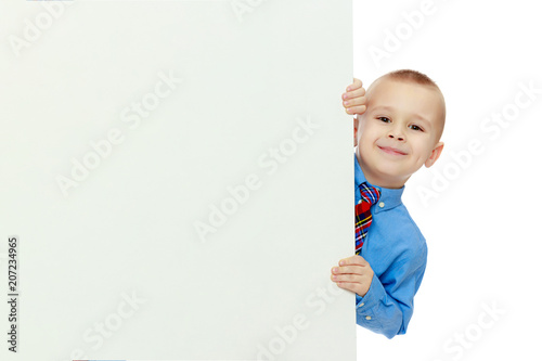 boy peeks out from behind the banner