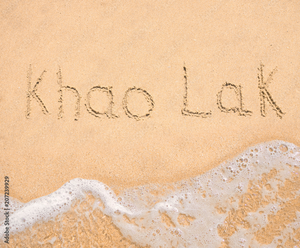 Fototapeta premium The word Khao Lak written in the sand on beach