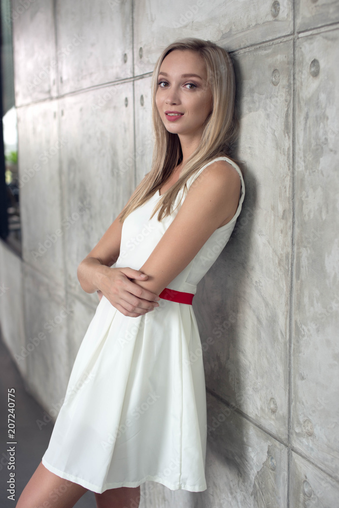 Blond girl lean against the wall