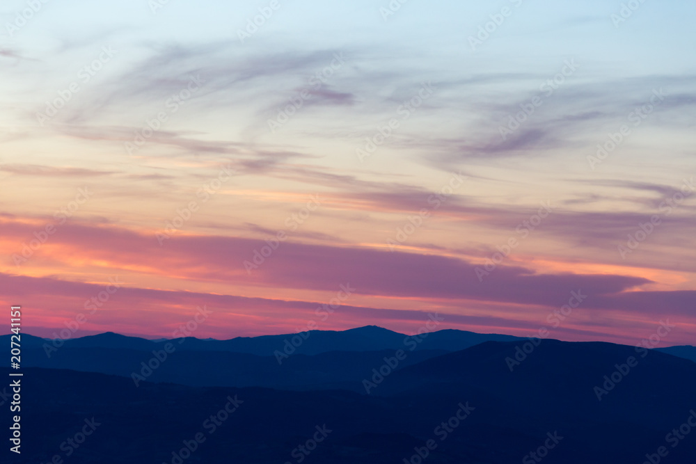 Layers of mountains and hills at sunset, with warm and soft tone