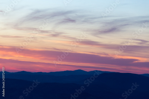 Layers of mountains and hills at sunset, with warm and soft tone
