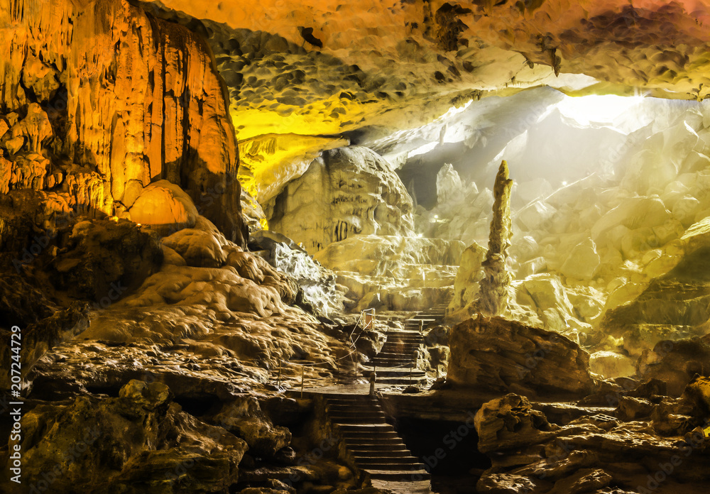 Beautiful view of gold sunlight shining through Sung Sot Cave or Surprise Grotto on Bo Hon Island is one of finest and widest grottoes of Ha Long Bay, situated in center of UNESCO World Heritage area
