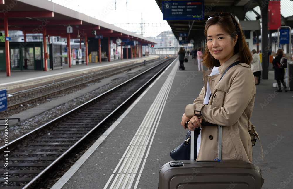 A girl is wating a train in a trian station at Geneva, Switzerland.