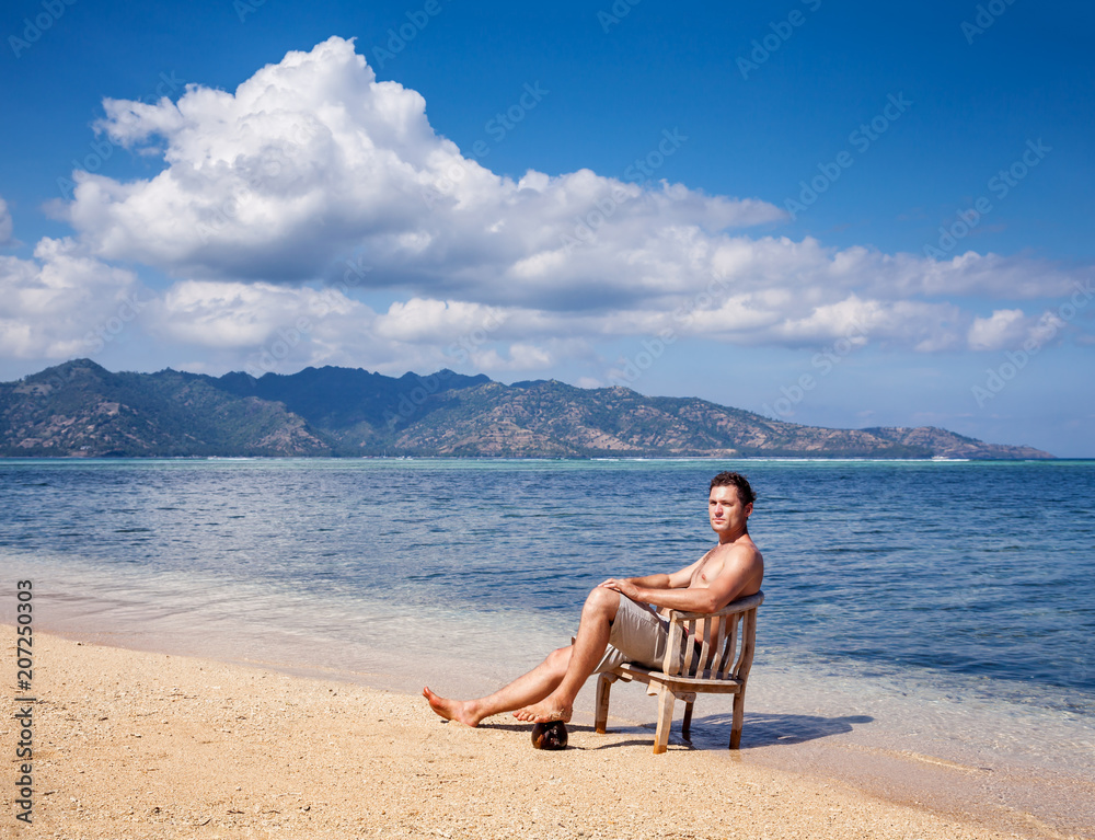 Young man in chair resting on the beach