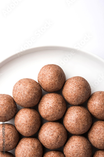 Nachni laddu or Ragi laddoo or balls made using  finger millet  sugar and ghee. It s a healthy food from India. Served in a bowl or plate over moody background. Selective focus