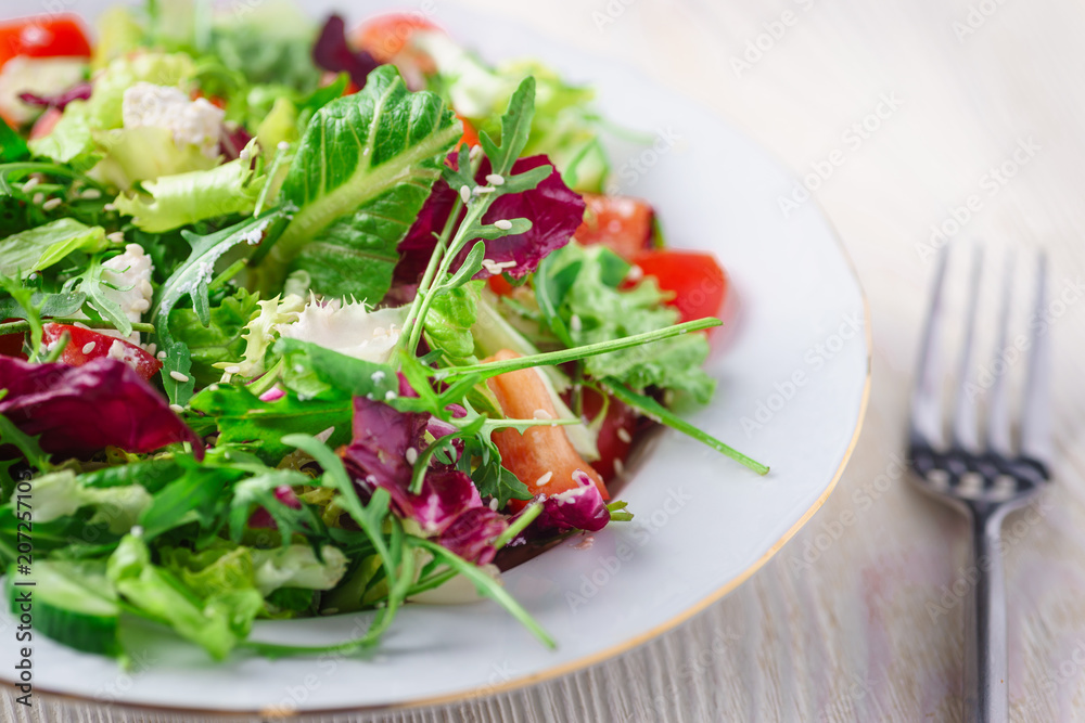 Fresh organic super food salad on white plate with fork on side Fresh organic super food salad on white plate with fork on side