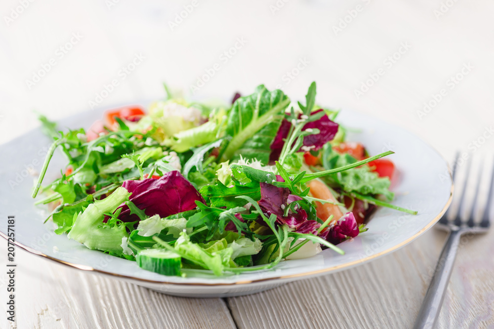 Fresh organic super food salad on white plate with fork on side Fresh organic super food salad on white plate with fork on side