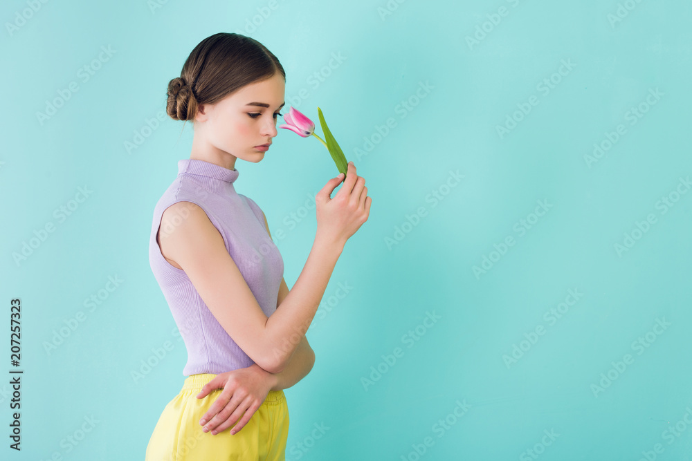 tender teen girl posing with tulip flower, isolated on turquoise tender teen girl posing with tulip flower, isolated on turquoise