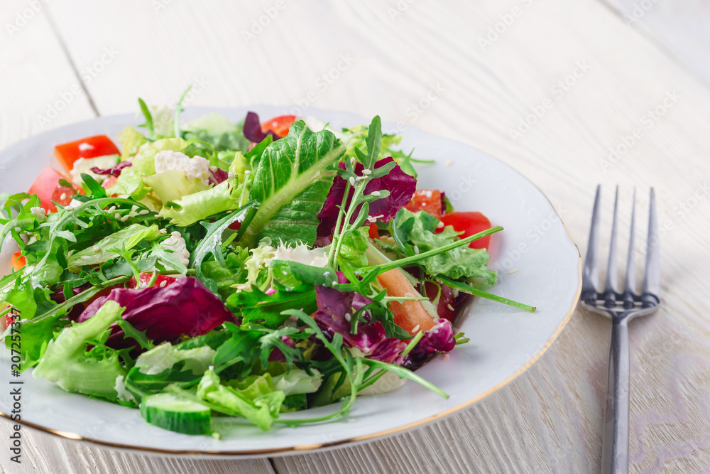 Fresh organic super food salad on white plate with fork on side Fresh organic super food salad on white plate with fork on side