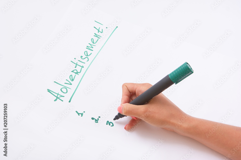 advertisement. a female hand writing on a white paper writes a hand.