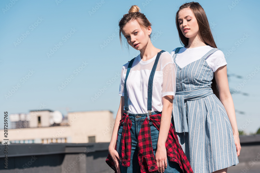 two young female friends standing at rooftop