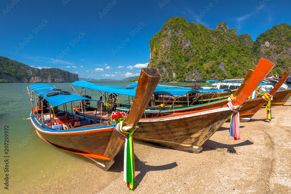 Fototapeta premium Long Tail Boat, traditional wooden boats, in James Bond island, Khao Phing Kan, Phang Nga Bay, Ao Phang Nga National Park, Krabi Province, Thailand.