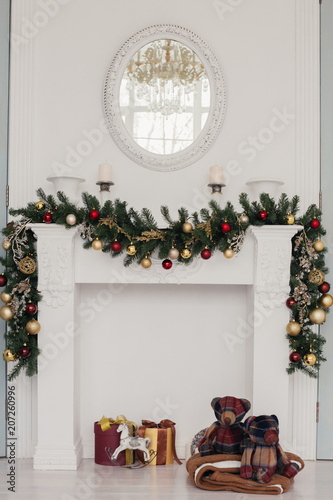 white fireplace decorated by christmas ornaments