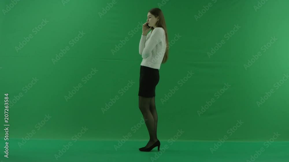 girl looks at the left and talks on the phone on green screen girl looks at the left and talks on the phone on green screen