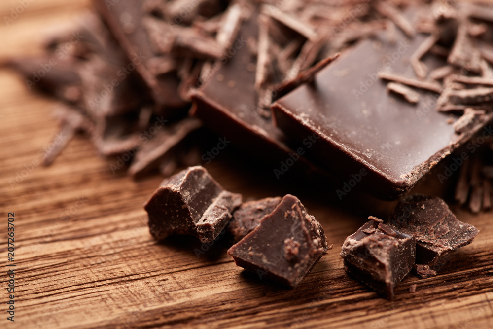 crumbs of black chocolate on a wooden background crumbs of black chocolate on a wooden background