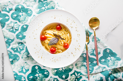 Spaghetti pasta with cherry tomatoes on white plate