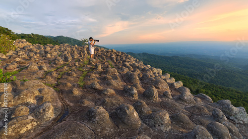 Professional photographer takes photos with mirror camera on peak of rock.Dreamy landscape