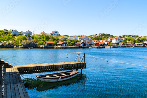 The coastal village of Storkalv, seen from across the sound Kalvesund outside Ronnang on Tjorn, Sweden. Small rowboat tied to a pier in the foreground.