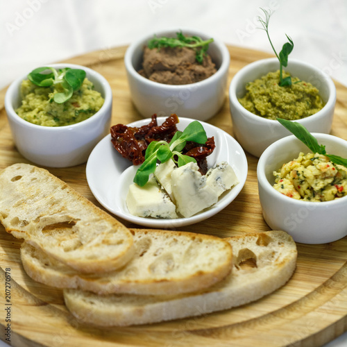 four types of pate with dried tomatoes, cheese and croutons photo