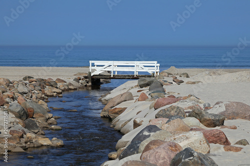 Eine weiße Brücke über einem kleinen Fluss, der in der Nrodsee mündet