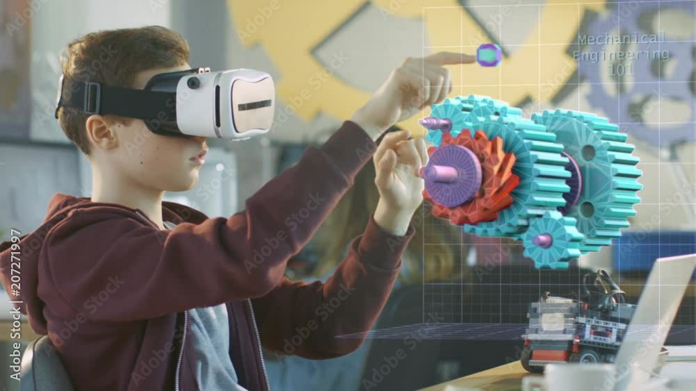 In a Computer Science Class Boy Wearing Virtual Reality Headset Works in Interactive 3D Environment. Mechanical Modeling Project of Connecting Gears with Augmented Reality Software. 4K UHD.