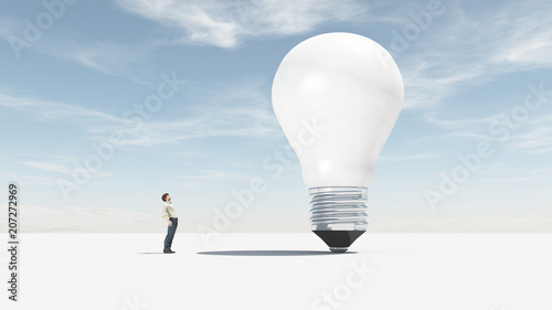 The man looks up towards a big bulb. photo