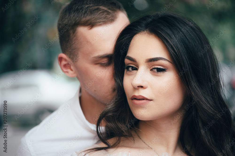 Happy young couple in love enjoys spring day, loving man holding on hands his woman carefree walking at park Happy young couple in love enjoys spring day, loving man holding on hands his woman carefree walking at park
