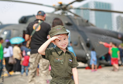 Portrait of asian child girl wearing airforce pilot suit against blur helicopter background. © zilvergolf