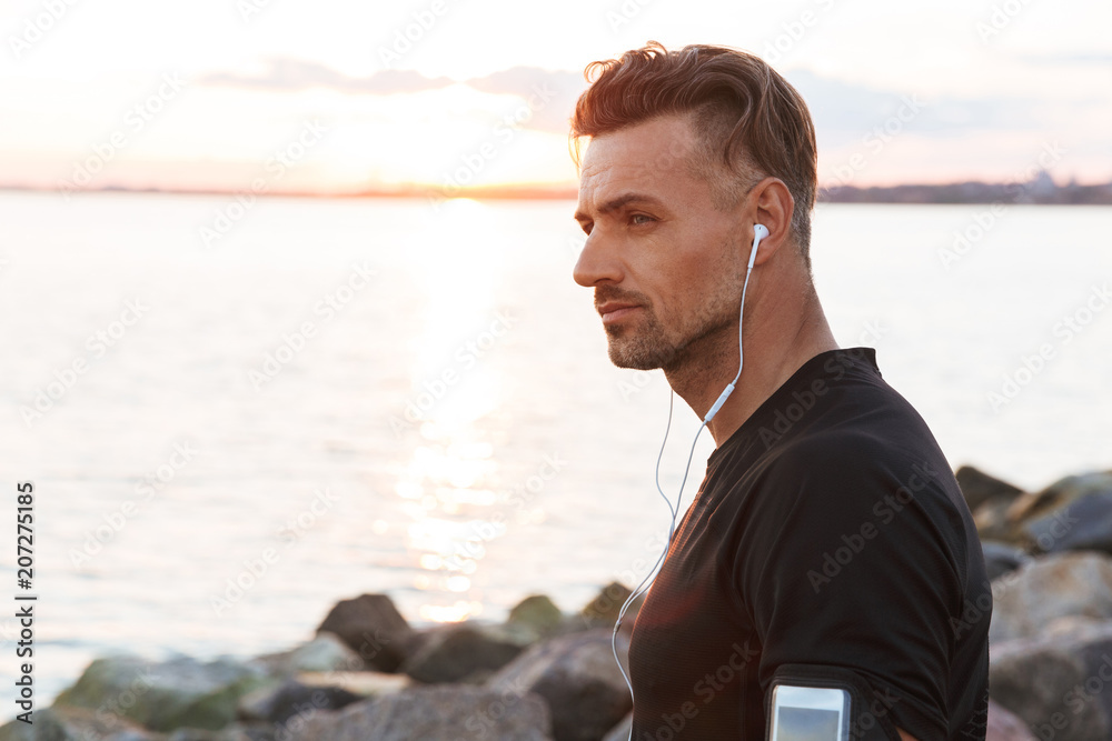 Close up portrait of a focused sportsman listening to music