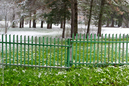 Деревянный забор между зимой и летом