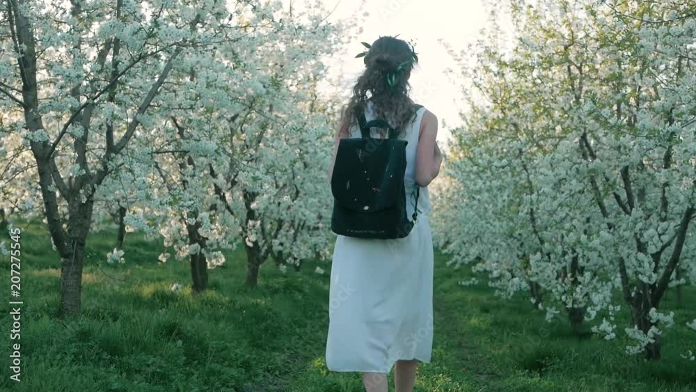 girl walking on a blooming garden and resting girl walking on a blooming garden and resting