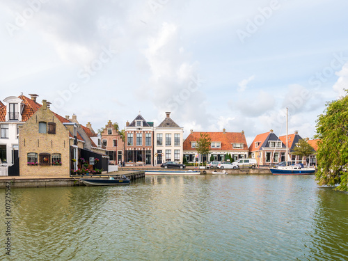 Harbour with boats and quayside with houses in old town of Makkum, Friesland, Netherlands