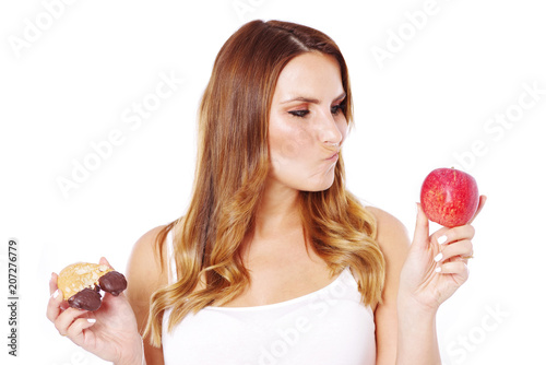 Frau mit gesundem und ungesundem Essen, Apfel oder süßes Gebäck   photo