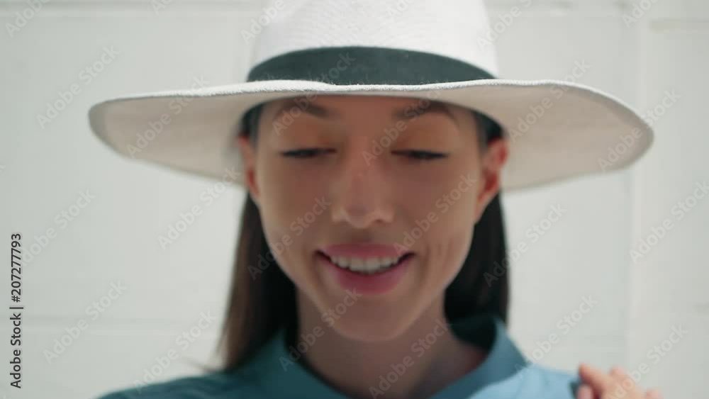 Portrait of Happy Stylish Charming young mixed race woman Fashion Blogger in blue summer dress and white hat posing on the summer street, sun is shining Portrait of Happy Stylish Charming young mixed race woman Fashion Blogger in blue summer dress and white hat posing on the summer street, sun is shining