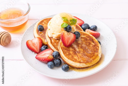 pancake with blueberries, strawberries, honey and vanilla ice-cream