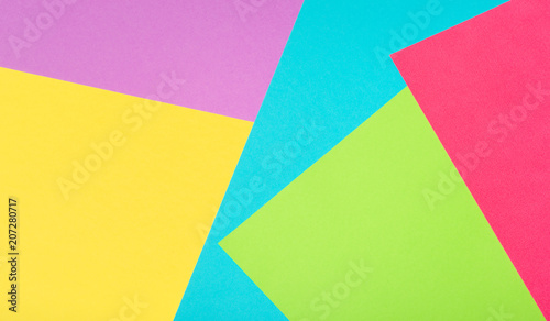 multi-color paper geometric background made of cardboard sheets. yellow, turquoise, light green, purple, red shapes and triangles